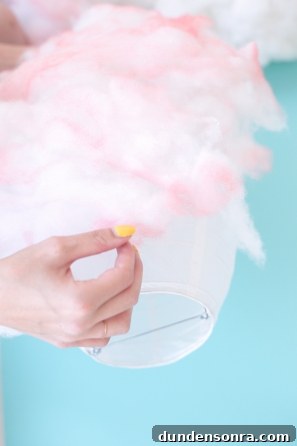 How to Make a Cotton Candy Piñata for Parties and Birthdays 8 Someone holding pink cotton candy