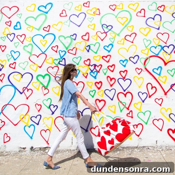 Studio DIY Wall Crawl: Top Murals and Walls to See in Los Angeles 11 A woman in front of a rainbow heart mural