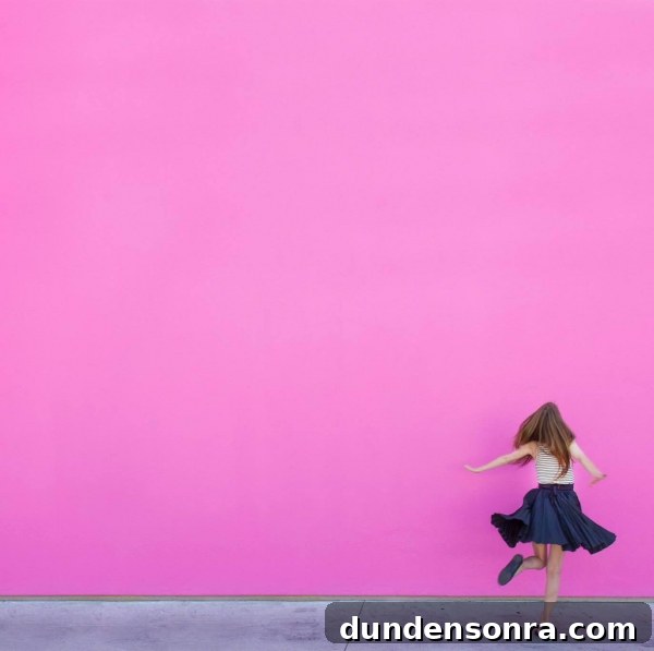 Studio DIY Wall Crawl: Top Murals and Walls to See in Los Angeles 4 A woman walking in front of a pink wall