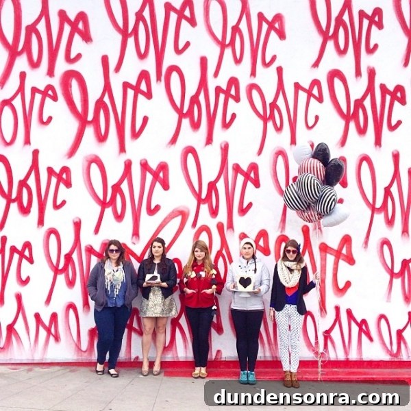 A group of people in front of a red mural