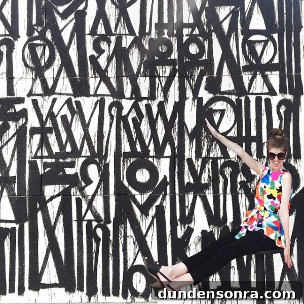 A woman in front of a black and white mural