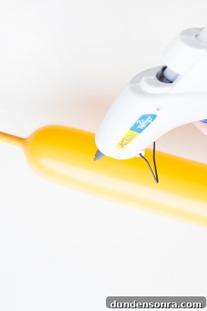 Someone gluing a yellow balloon