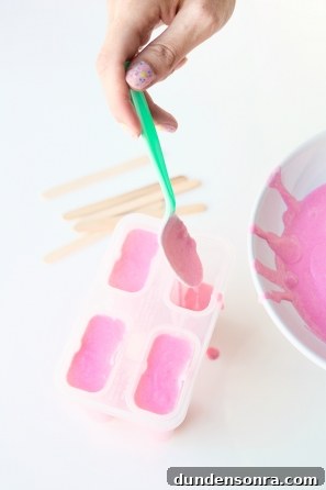 Someone putting pink liquid in a tray