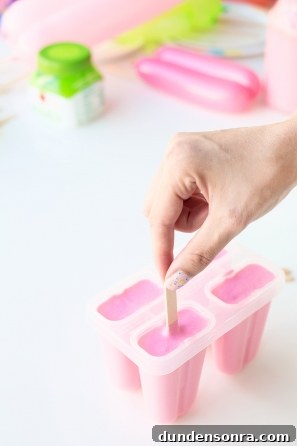 Summer Dreamsicle Party Ideas for a Bright, Refreshing Bash 10 Someone making a pink popsicle
