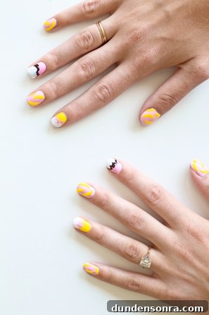 Someone with pink and yellow nails