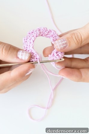Someone knitting a pink ring