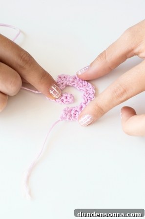 Someone sewing a pink shape