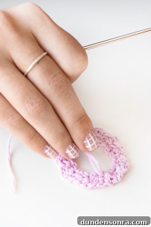 Someone sewing a pink shape