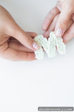 Someone holding a knitted "M" 