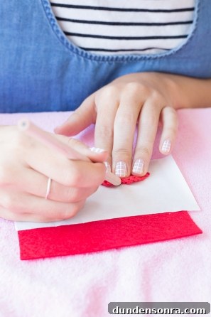 Someone putting a red item on pink fabric