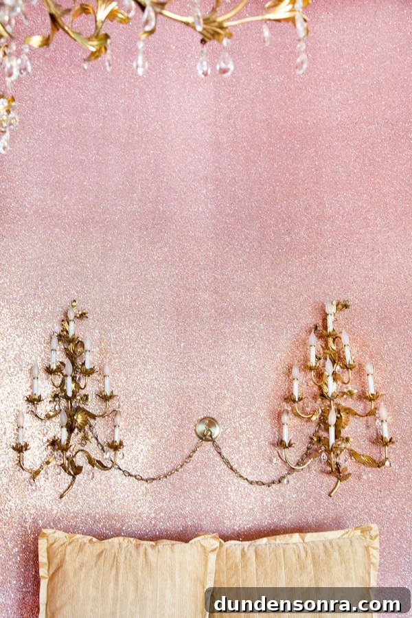 A close up a chandelier on a pink wall