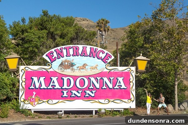 A pink sign that says "entrance madonna inn"