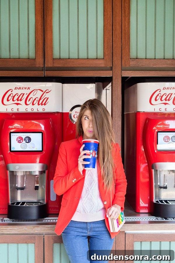 3 Bold Colorful Fall Outfits to Elevate Your Wardrobe 5 A woman standing in front of a coke machine, drinking a coke