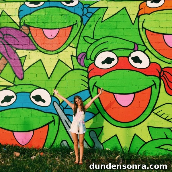 A woman standing in front of a colorful mural
