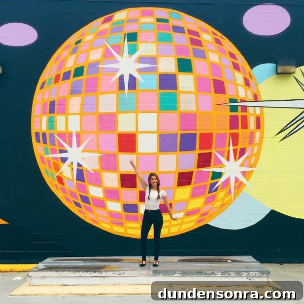 A woman standing in front of a disco ball mural