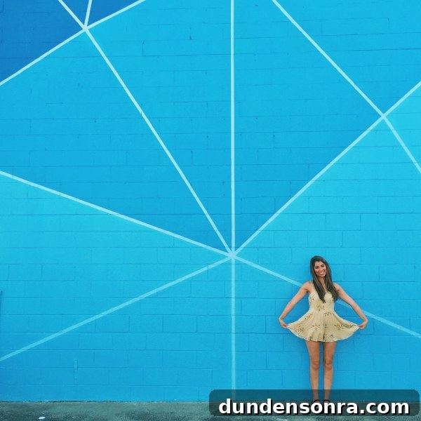 A woman standing in front of a blue mural