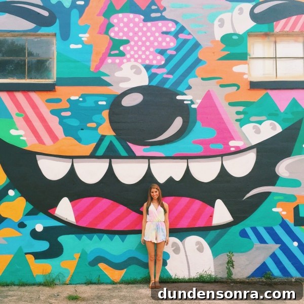 A woman standing in front of a colorful mural