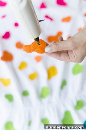 DIY Lisa Frank Costume Ideas for Colorful 90s-Inspired Looks 22 Someone gluing orange felt on a white shirt