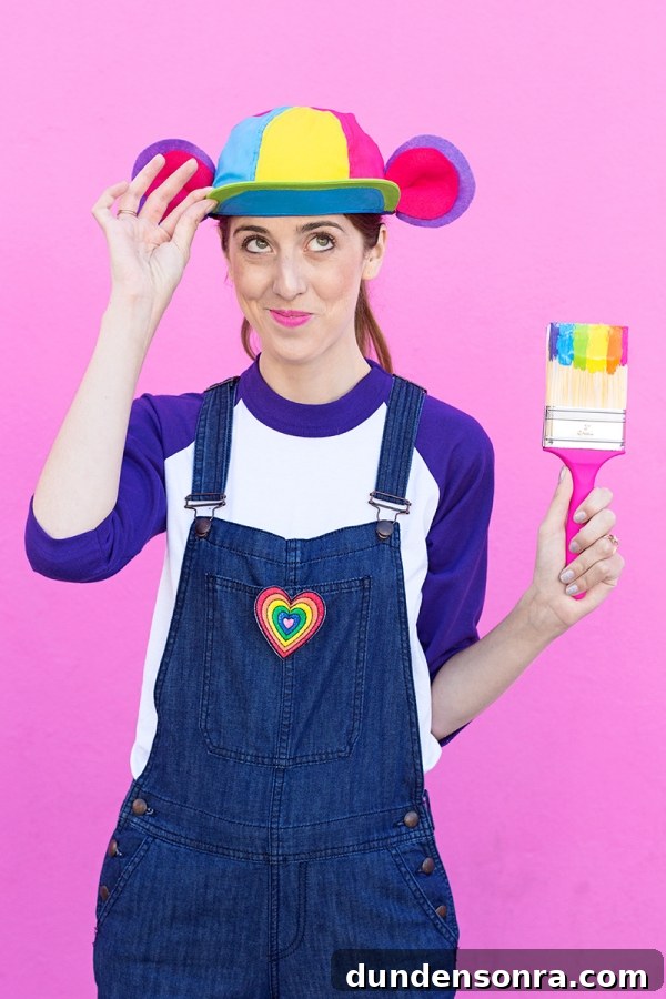 DIY Lisa Frank Costume Ideas for Colorful 90s-Inspired Looks 25 A woman wearing overalls and holding a rainbow paint brush