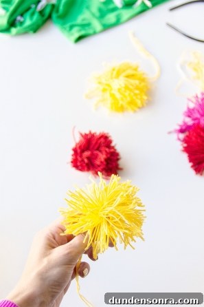 Someone holding a yellow yarn flower