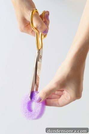 Someone cutting a purple styrofoam ring 