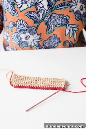 Someone sewing something beige and red