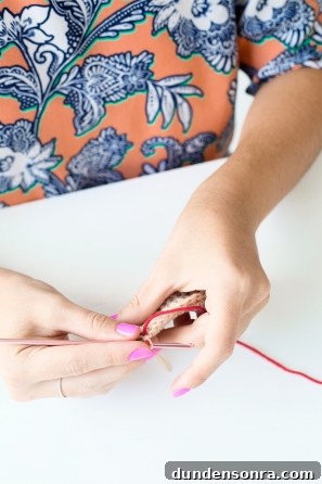 Someone sewing something beige and red