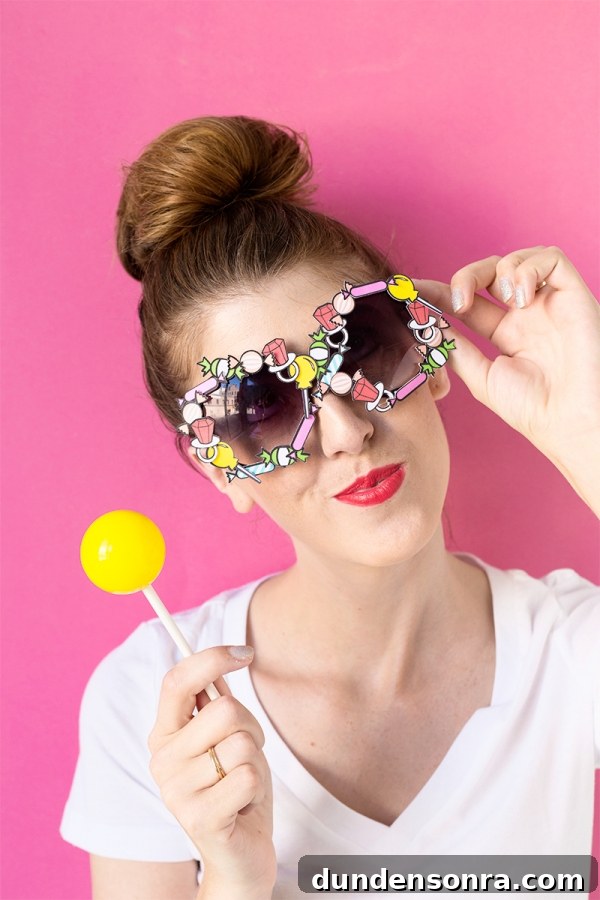 Someone wearing glasses and holding a lollipop 