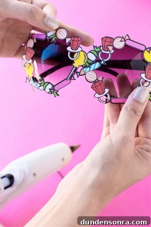 Someone holding sunglasses and a glue gun