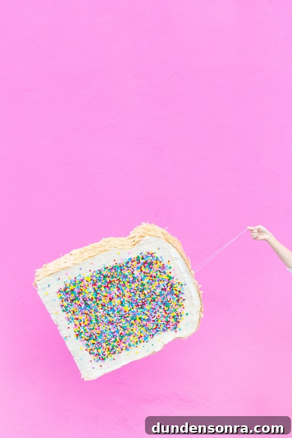 A woman holding a fairy bread pinata 
