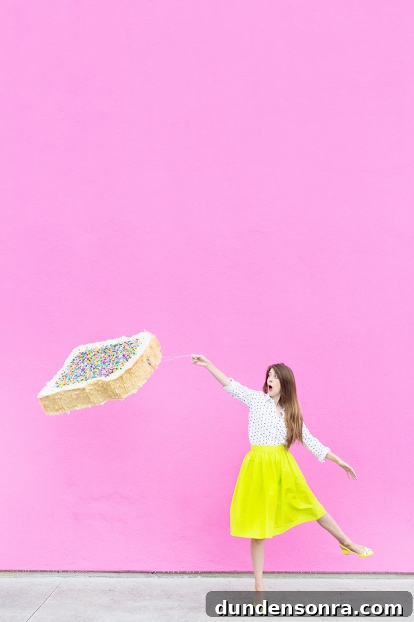 A woman in a yellow skirt and holding a fairy bread pinata 