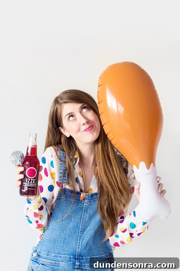 Someone holding an izze and a blow up chicken leg