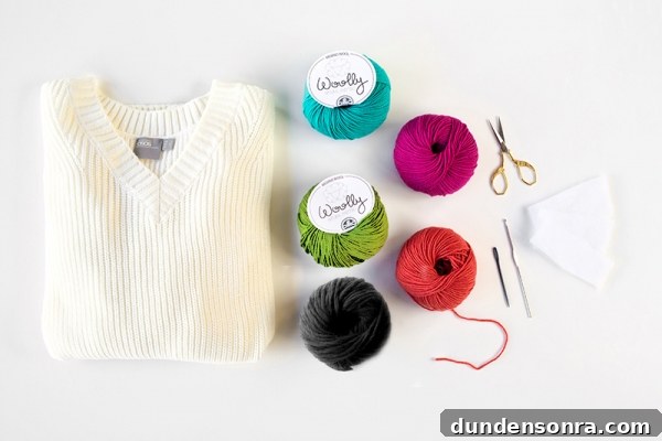 A white sweater, yarn, and scissors 