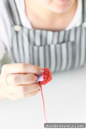 Someone sewing an orange item