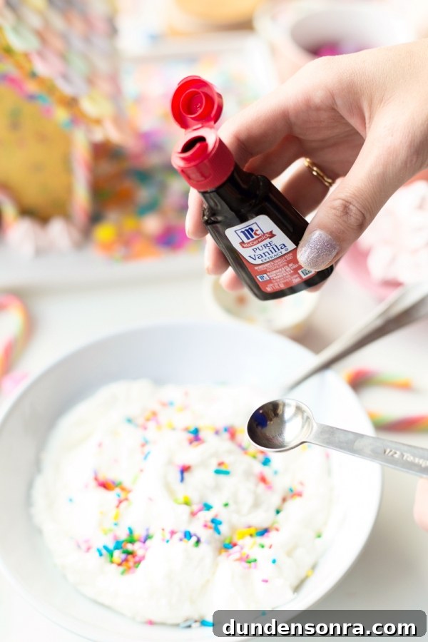 Funfetti Sugar Cookie House Recipe — Colorful Party Treat 5 Someone holding vanilla extract