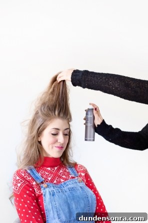 Someone using hairspray in a woman's hair