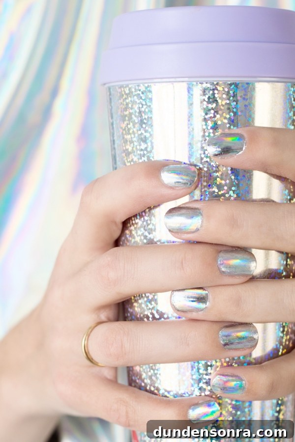 A woman with silver nails holding a silver cup