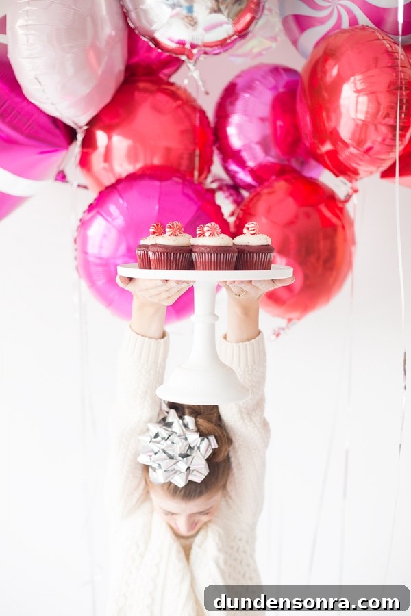 A woman holding a plate of cupcakes