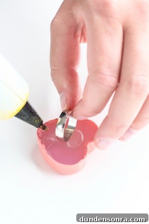 DIY Conversation Heart Rings: Make Cute Candy Heart Jewelry at Home 8 Someone gluing a heart item