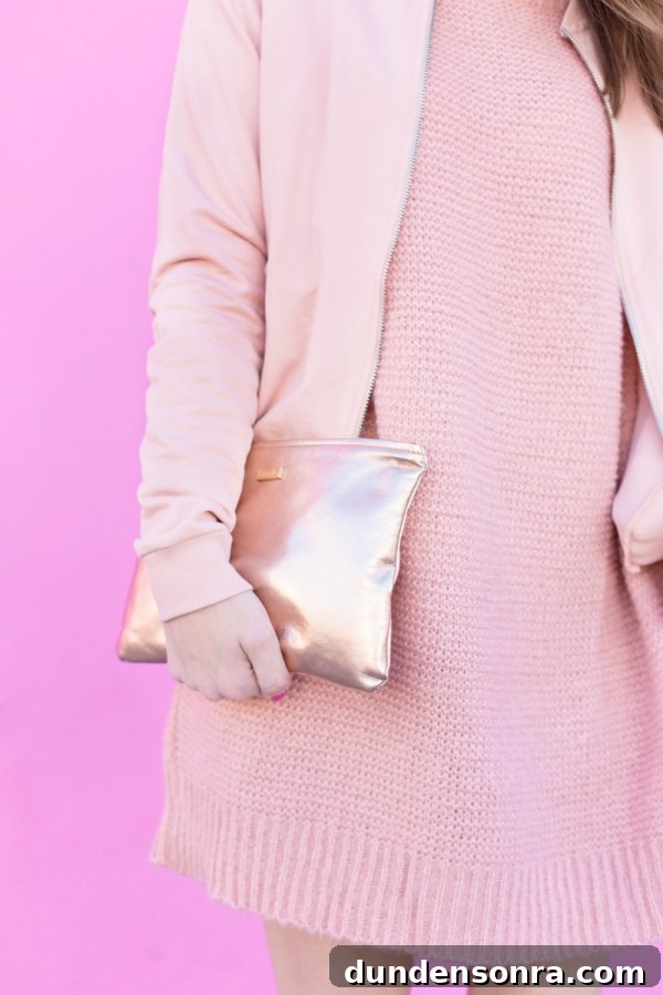 A woman wearing a pink outfit and holding a pink bag