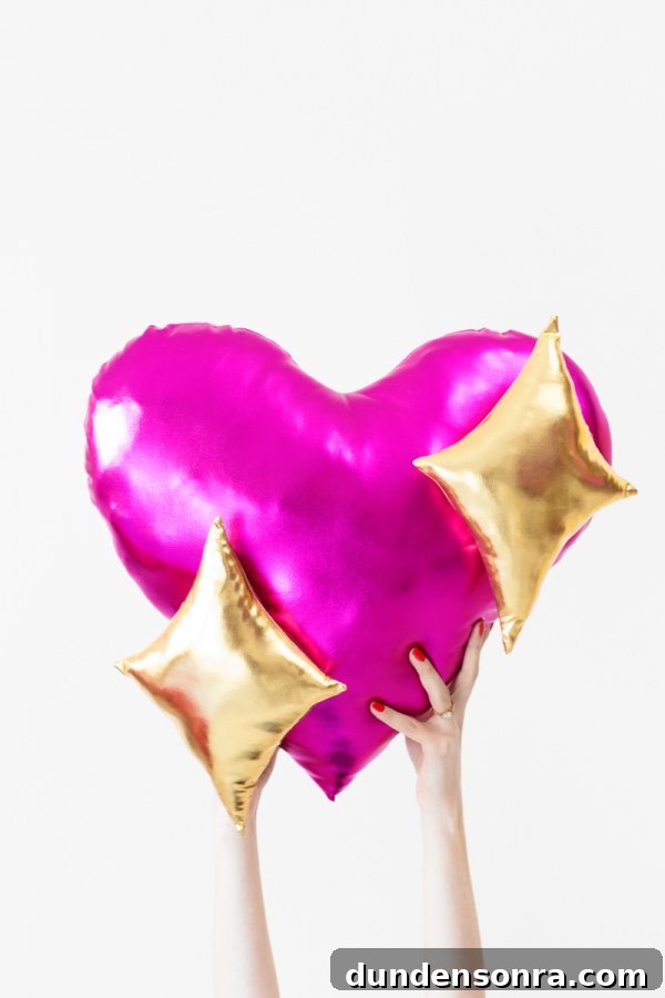 Someone holding a pink heart pillow with gold stars