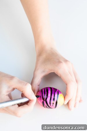 DIY Lisa Frank Easter Eggs: Vintage-Inspired Colorful Egg Ideas 9 Someone drawing on an egg
