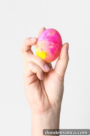 DIY Lisa Frank Easter Eggs: Vintage-Inspired Colorful Egg Ideas 8 Someone holding a colorful egg