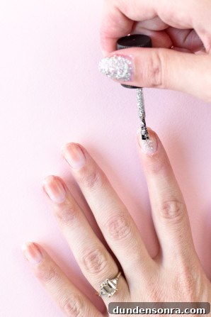 Someone painting their nails silver