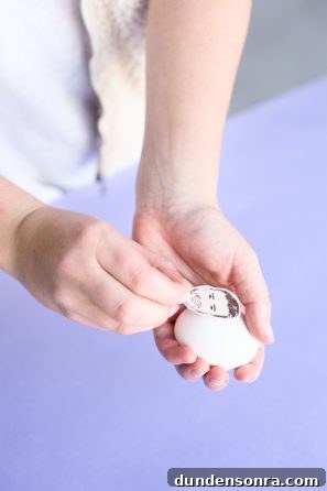 Celebrity-Inspired DIY Easter Egg Ideas for a Stylish Holiday 6 Applying face sticker to egg