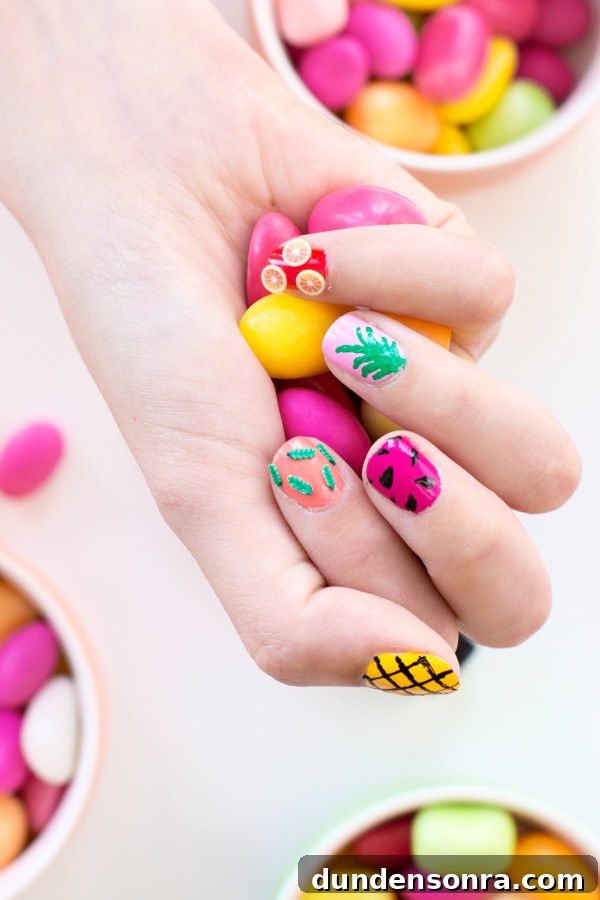 Someone with colorful nail polish holding candy 
