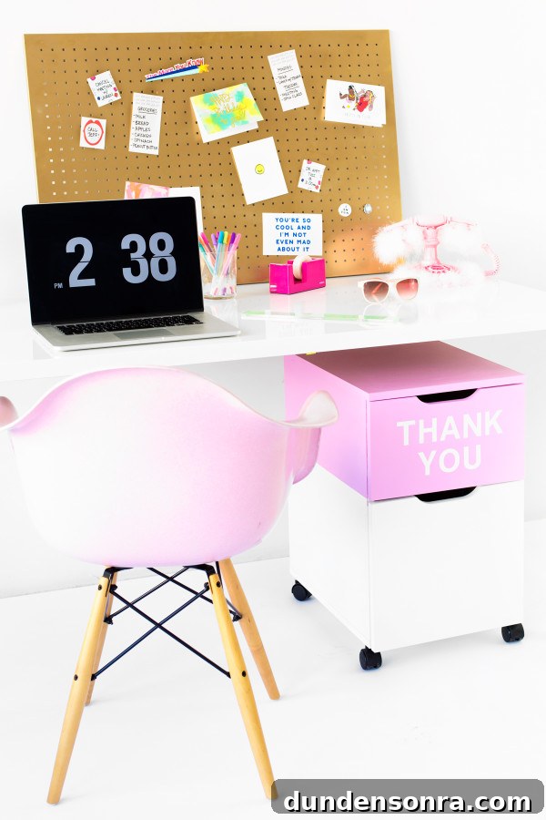 A desk with a pink chair and a computer