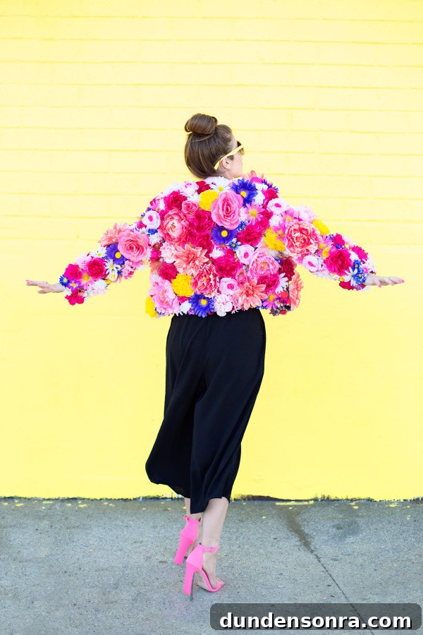 A woman wearing a floral jacket in front of a yellow wall
