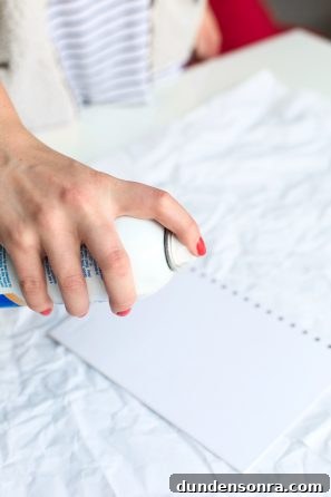 Someone spraying a paper