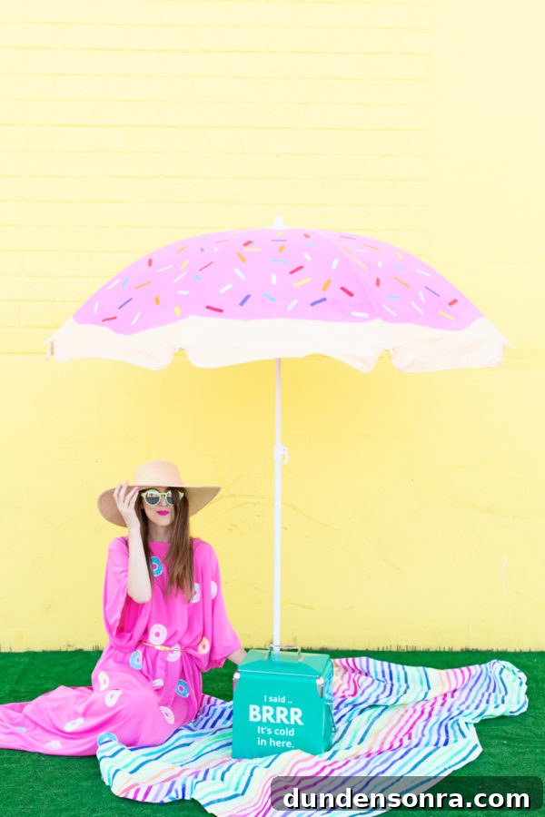 A woman sitting under a pink umbrella